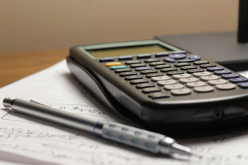 picture of a calculator, pen and notebook